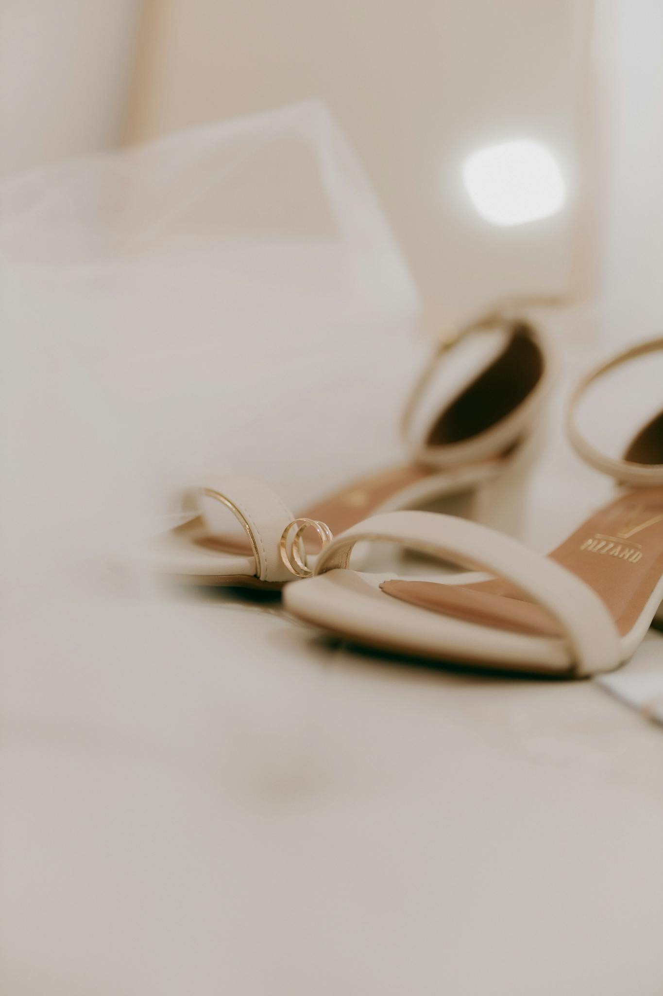 Close-up of elegant bridal shoes with a wedding ring, symbolizing love and commitment.