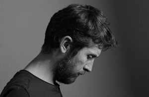 Monochrome side profile portrait of a contemplative man with a beard in France.